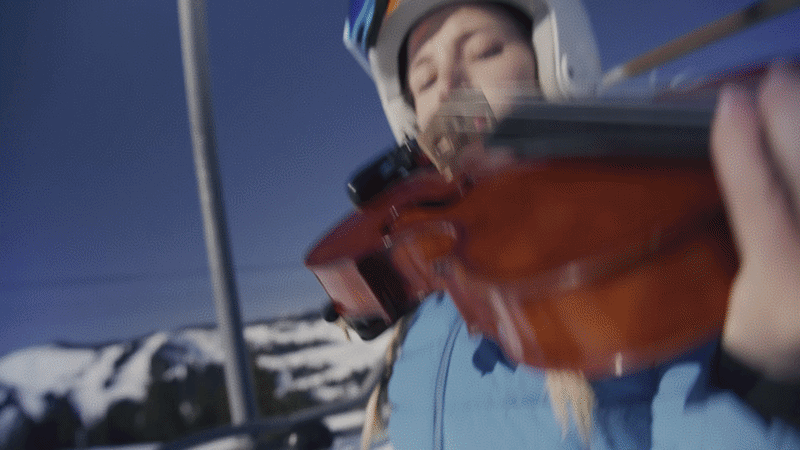A man and woman sitting on an illuminated bench by the water at night